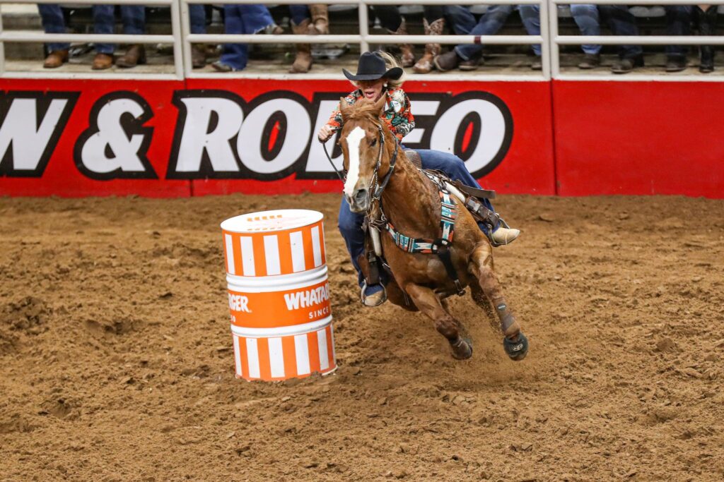 Margo Crowther and her horse turn the first barrel in the barrel racing in San Antonio.