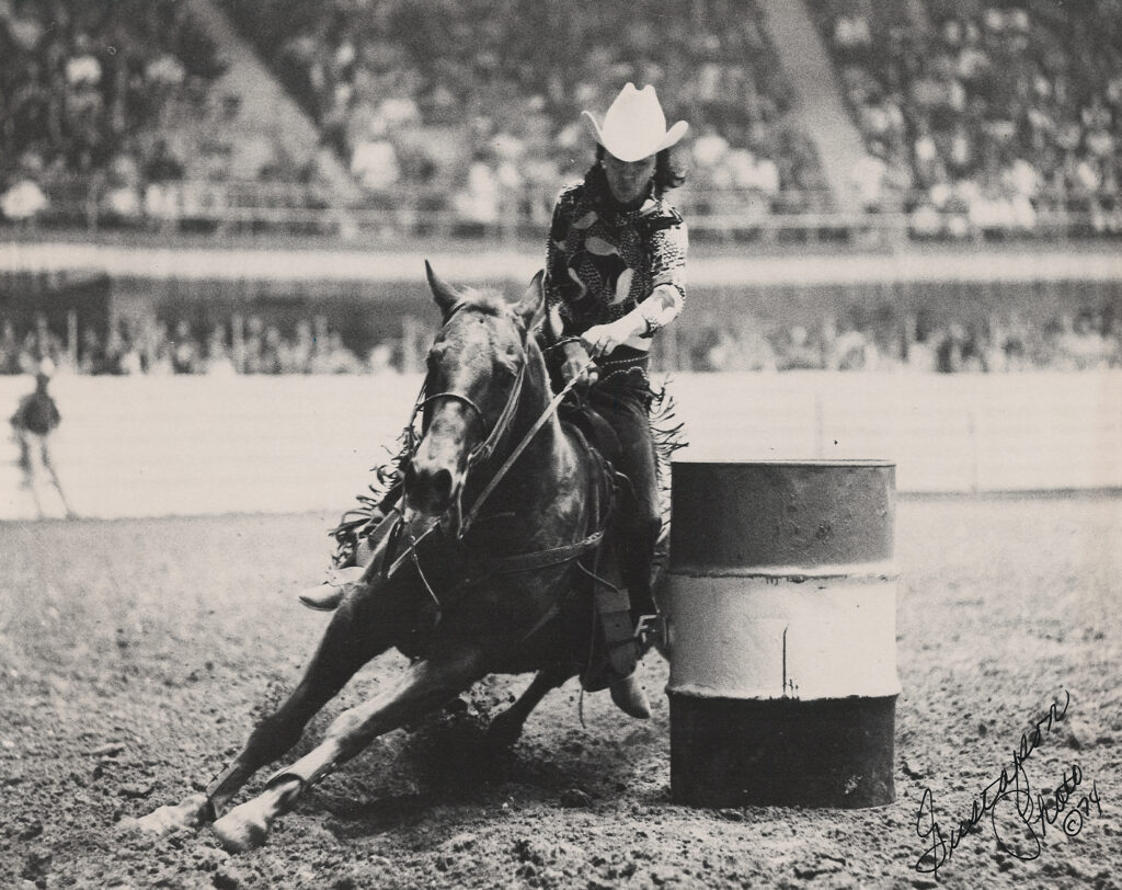 Cowgirl competes in barrel racing at 1974 rodeo.